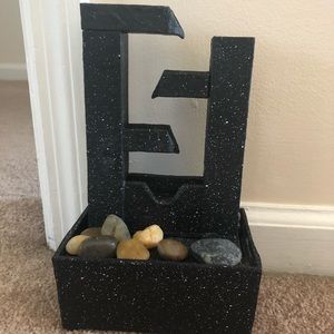 Water fall with rocks and lights next to rocks